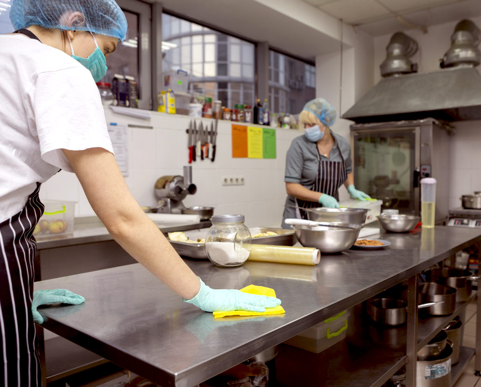 Women food prepping and cleaning commercial kitchen
