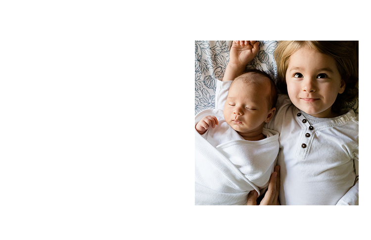 Newborn baby with proud toddler sibling